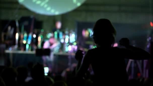 Выстрел фанатов группы поддержки на концерте, замедленная съемка. Девушка на концерте сидя на плечах и поднимая руки — стоковое видео