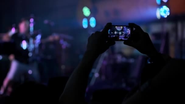 Persone che scattano foto o registrano video con i loro smartphone al concerto di musica rock in un night club. heavy metal band esegue .. — Video Stock