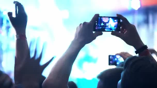 Pessoas tirando fotos ou gravando vídeo com seus smartphones em um concerto de música rock em uma boate. banda de heavy metal executa .. — Vídeo de Stock