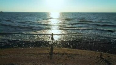 Hava ağır çekim: okyanus yukarıda uçurumun tepesinde duran genç kadın üzerinde uçan