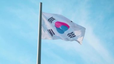 Güney Kore bayrağı mavi gökyüzü bulutlu karşı rüzgarda sallayarak bayrak direği üzerinde. Ağır çekim, yüksek hızlı kamera, 120fps