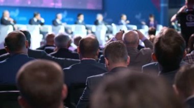 Bir eski işadamı ya da politikacı bir seminere dinleme veya ekonomik durumla ilgili ders. Fotoğraf yapar veya Smartphone'da video çekimleri.