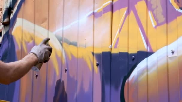 Молодий хлопець з балончиком фарби малює графіті на стіні. Одна рука крупним планом . — стокове відео