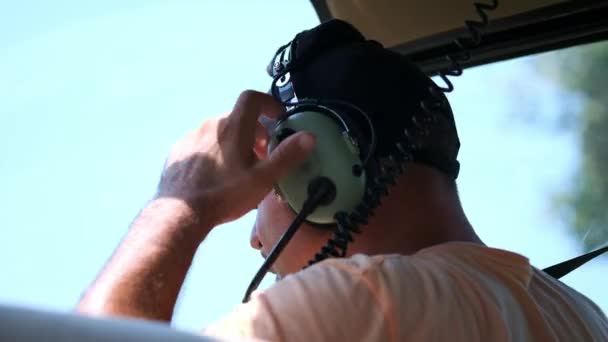 The helicopter pilot puts on the headset for negotiations with the dispatcher. Requests takeoff permission — Stock Video