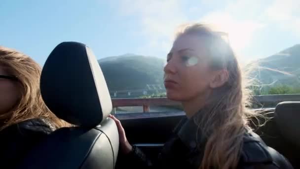 Beautiful smiling blondie rides in a back seat of a convertible car freedom concept — Stock Video