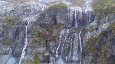 Anteni: dağ şelale kayaların üzerinden akar. Yukarıda büyük dağ buzulu.