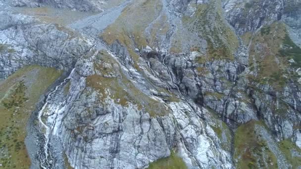 Antenn: mountain vattenfall rinner över klipporna. Ovanför glaciären stort berg. — Stockvideo