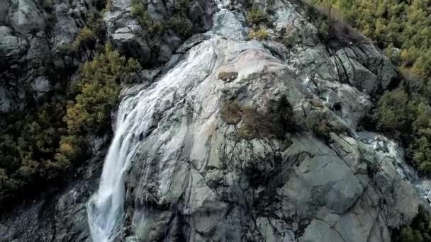 Anteni: dağ şelale kayaların üzerinden akar. Yukarıda büyük dağ buzulu. — Stok video