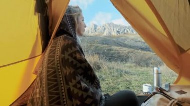 güzel sarışın genç kadın çadır kamp sadece üzerinde büyük dağ girin. Yalnızlık Dağları arasında Özgürlük kavramı. Bir panço giyinmiş. Crimea.