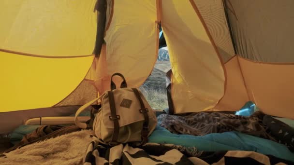 魅力的な女の子のハイキングは、テントからバックパックをピックアップします。山をくすぐるまでの距離になります。休暇を楽しんでいます。山の中の自由の概念。クリミア半島 — ストック動画