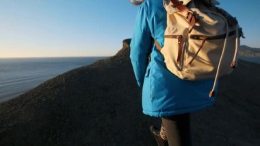 genç çekici kız uzun yürüyüşe çıkan kimse kumlu çıkıntıları veya deniz cliff gider. Ellerini yukarı yükseltir, altın gündoğumu veya günbatımı görünüyor. Başarı duygusu sahiptir. Yüksek bir güzel dağda tırmanıyor.