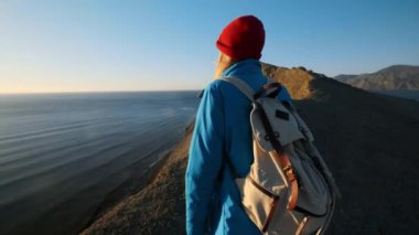 genç çekici kız uzun yürüyüşe çıkan kimse kumlu çıkıntıları veya deniz cliff gider. Ellerini yukarı yükseltir, altın gündoğumu veya günbatımı görünüyor. Başarı duygusu sahiptir. Yüksek bir güzel dağda tırmanıyor.