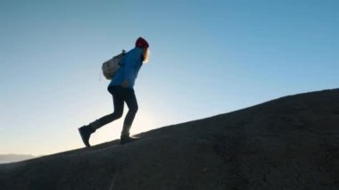 genç çekici kız uzun yürüyüşe çıkan kimse kumlu çıkıntıları veya deniz cliff gider. Ellerini yukarı yükseltir, altın gündoğumu veya günbatımı görünüyor. Başarı duygusu sahiptir. Yüksek bir güzel dağda tırmanıyor