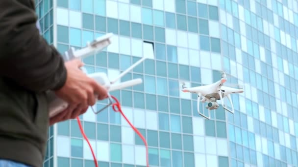 Egy fiatal férfi egy férfi egy modern műszerfal és egy Rc adó quadrocopter szabályozza. Ember repül, és a forgatás kamera drone — Stock videók