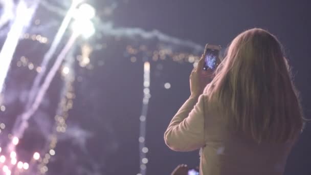 Flicka skytte Salut på din smartphone. ung flicka fotograferar fyrverkerier på din smartphone. Stadssemester, födelsedagen av staden. — Stockvideo