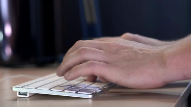 Gerente do sexo masculino digitando no teclado no escritório à noite. Um relógio inteligente é usado na mão. Close-up . — Vídeo de Stock