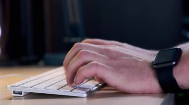 Erkek Yöneticisi Office klavye akşam yazarak. Akıllı bir saat yandan giyilir. Yakın çekim.