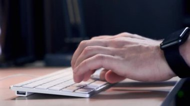 El ile akıllı saatini yakın çalışma alanında okul sırası klavye türü mans. Genç işadamı are çalışma zevk için yeni proje ile sanat başlamak yukarıya bilgisayar kapalı.