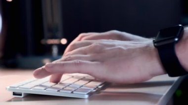 El ile akıllı saatini yakın çalışma alanında okul sırası klavye türü mans. Genç işadamı are çalışma zevk için yeni proje ile sanat başlamak yukarıya bilgisayar kapalı.