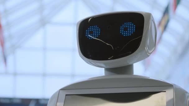 Robotika modern technológia. A robot úgy néz ki, a kamera, az a személy. Portréja egy robot, elfordítja a fejét. Fehér modern robot a kiállításon, az új technológiák. — Stock videók