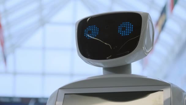 Technologies robotiques modernes. Le robot regarde la caméra vers la personne. Portrait d'un robot, tourne la tête. Robot moderne blanc à l'exposition des nouvelles technologies . — Video