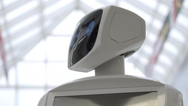 Nowoczesnych technologii robotów. Robot patrzy w kamerę na osobę. Portret robota, odwraca głowę. Białe nowoczesne robot na wystawie nowe technologie. — Wideo stockowe