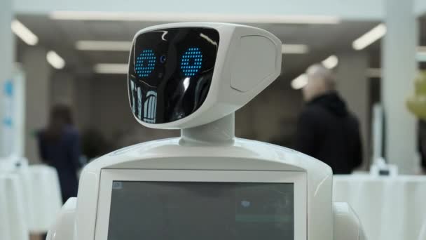 Сучасні робототехнічні технології. Робот дивиться на камеру у людини. Портрет робота, повертає голову. Білий сучасний робот на виставці нових технологій . — стокове відео