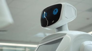 Modern Robotik teknolojiler. Robot kişi kameraya bakar. Bir robot portresini kafasını döner. Beyaz modern robot yeni teknolojilerin sergisinde.