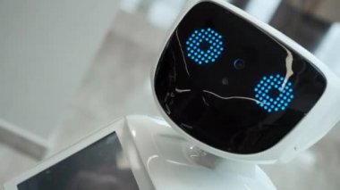 Modern Robotik teknolojiler. Robot kişi kameraya bakar. Bir robot portresini kafasını döner. Beyaz modern robot yeni teknolojilerin sergisinde.