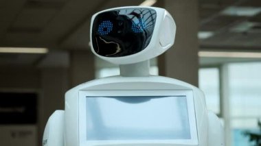 Modern Robotik teknolojiler. Robot kişi kameraya bakar. Bir robot portresini başını dönüyor, ellerini yukarı yükseltir. Beyaz modern robot yeni teknolojilerin sergisinde.