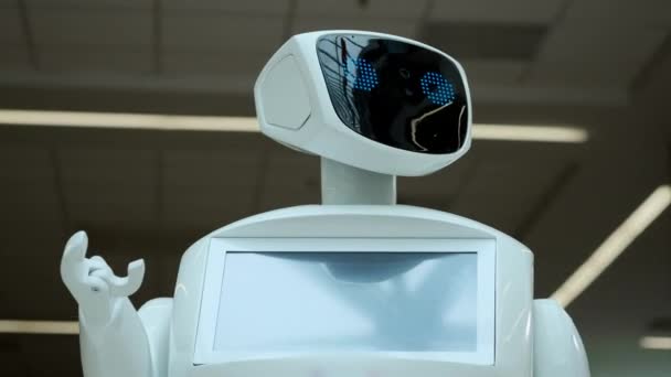 Современные роботизированные технологии. Робот смотрит в камеру на человека. Портрет робота, поворачивает голову, поднимает руки вверх. Белый современный робот на выставке новых технологий . — стоковое видео