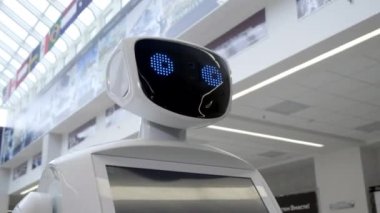 Modern Robotik teknolojiler. Robot kişi kameraya bakar. Bir robot portresini kafasını döner. Beyaz modern robot yeni teknolojilerin sergisinde