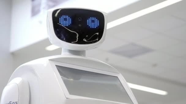 Κυβερνητικό σύστημα σήμερα. Σύγχρονη ρομποτικές τεχνολογίες. Πορτραίτο του ρομπότ, γυρίζει το κεφάλι του, θέτει τα χέρια του επάνω. Λευκό σύγχρονη ρομπότ στην έκθεση των νέων τεχνολογιών — Αρχείο Βίντεο
