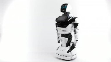 Modern Robotik teknolojiler. Parlak Studio robot. Android yükseltir ve beyaz zemin üzerine el düşürür. İyi ve kötü duygular gösterir. Kameraya bakarak