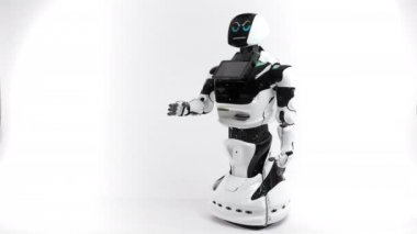 Modern Robotik teknolojiler. Parlak Studio robot. Android yükseltir ve beyaz zemin üzerine el düşürür. İyi ve kötü duygular gösterir. Kameraya bakarak