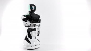 Modern Robotik teknolojiler. Parlak Studio robot. Android yükseltir ve beyaz zemin üzerine el düşürür. İyi ve kötü duygular gösterir. Kameraya bakarak