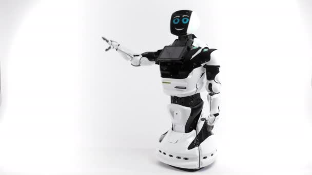 Modern Robotic teknik. Robot i ljusa studion. Android höjer och sänker händerna på en vit bakgrund. Vifta med en hälsning hand — Stockvideo