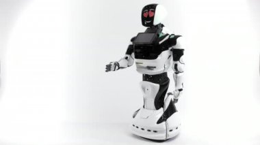 Modern Robotik teknolojiler. Parlak Studio robot. Android yükseltir ve beyaz zemin üzerine el düşürür. İyi ve kötü duygular gösterir. Kameraya bakarak