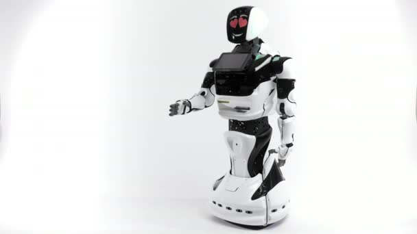 Tecnologie robotiche moderne. Robot nello studio luminoso. Android solleva e abbassa la mano su uno sfondo bianco. Mostra il male e le emozioni buone. Guardando la macchina fotografica — Video Stock