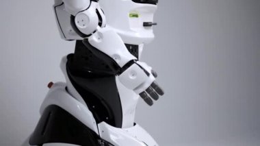 Modern Robotik teknolojiler. Beyaz modern robot parlak bir stüdyoda. Android elini virajlı, onun eklem gösterir. Beyaz zemin üzerinde bir robot gösteri. Burada gelecek