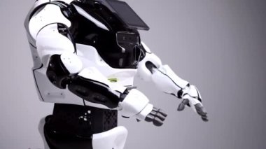 Modern Robotik teknolojiler. Beyaz modern robot parlak bir stüdyoda. Dans, kollarını sallayarak android. Beyaz zemin üzerinde bir robot gösteri. Burada gelecek.
