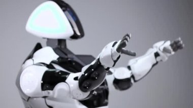 Modern Robotik teknolojiler. Beyaz modern robot parlak bir stüdyoda. Dans, kollarını sallayarak android. Beyaz zemin üzerinde bir robot gösteri. Burada gelecek.