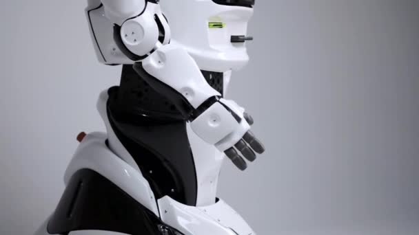 Tecnologías robóticas modernas. Robot blanco moderno en un estudio luminoso. Android dobla su mano, muestra sus articulaciones. Demostración de un robot sobre un fondo blanco. Futuro aquí — Vídeo de stock