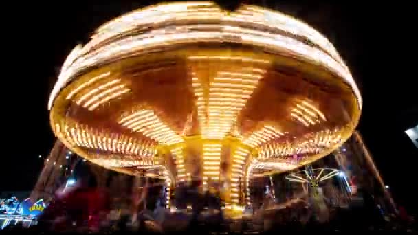 Feliz carrusel de ronda por la noche. Carrusel del parque de atracciones con caballos de madera bellamente pintados . — Vídeos de Stock