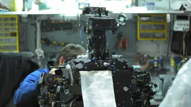 Forskaren skapar en modern robot eller android. Kontrollerar mekanismen i räcka av roboten. Tillverkning och framställning av robotar. — Stockvideo