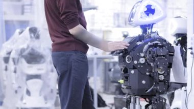 Mühendis robot ayarlar. Yeni bir robot kurar mühendislik. Tıkırtı üstünde belgili tanımlık perde robot. Program ile çalışır.