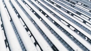 Anteni: Fotovoltaik kış karla kaplı. Güneş panelleri arasında karla kaplı kar sürüklenir. Kuzey ülkeleri alternatif enerji kaynakları.