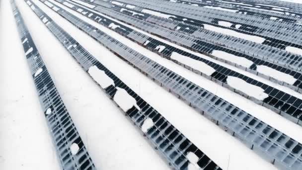 AERIAL: Fotovoltaica en invierno cubierta de nieve. Paneles solares entre las corrientes de nieve, cubiertos de nieve. Fuentes alternativas de energía en los países nórdicos . — Vídeos de Stock