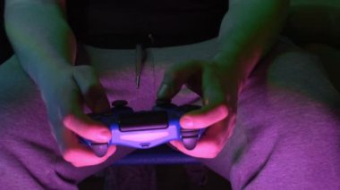 Genç adam el oyun konsolu Tv geniş ekran önünde video oyunları oynamak portre.