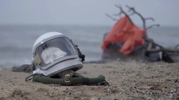 Dead astronaut on the planet. The skull from the head in the helmet lies on the sand by the sea. Troubled by accident. — Stock Video